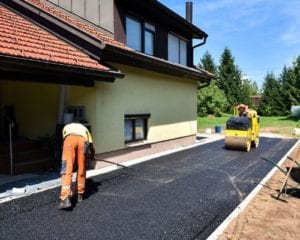 contractors are working driveway paving with asphalt